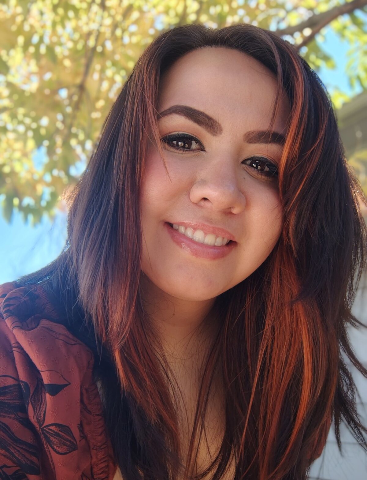 Katie smiling beneath autumn leaves